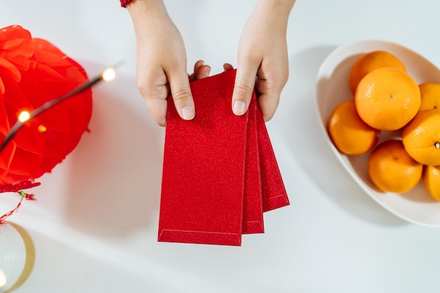 Foto aziatische vrouw die rode envelop geeft voor nieuwe maanjaarvieringen houd het rode pakje vast