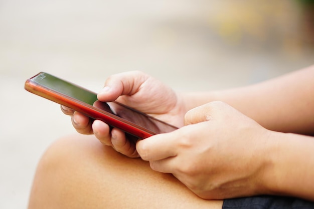 Aziatische vrouw die telefoon in park gebruikt