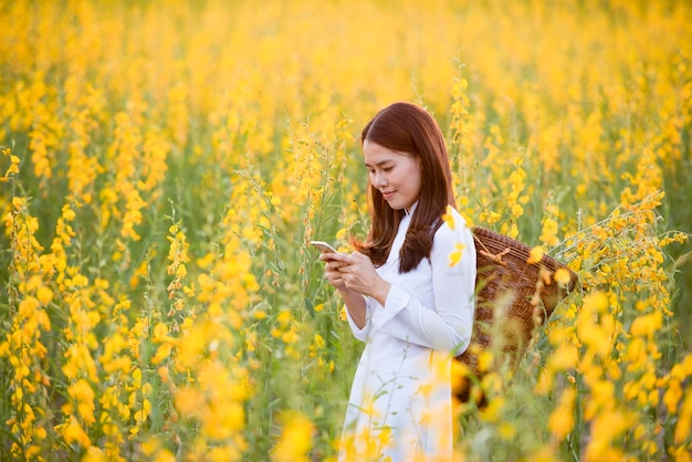 Aziatische vrouw die traditionele kleding draagt die sms't op een smartphone