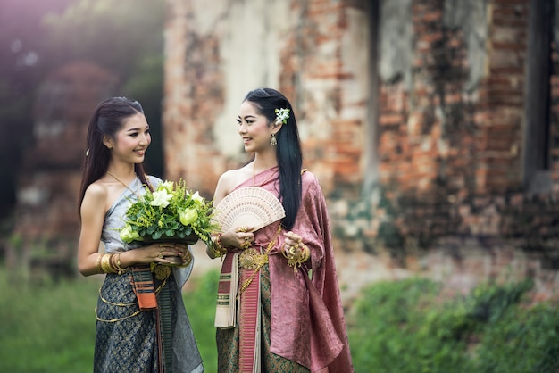 Aziatische vrouw die typische Thaise kleding, de uitstekende originele kleding van Thailand draagt