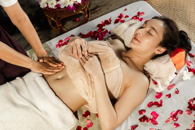 Aziatische vrouw die van een zoute scrubmassage geniet bij spa Gezondheidszorg spa en massage thais concept Meisje die holistische massagebehandeling krijgen Thaise masseusevrouw die massage krijgen