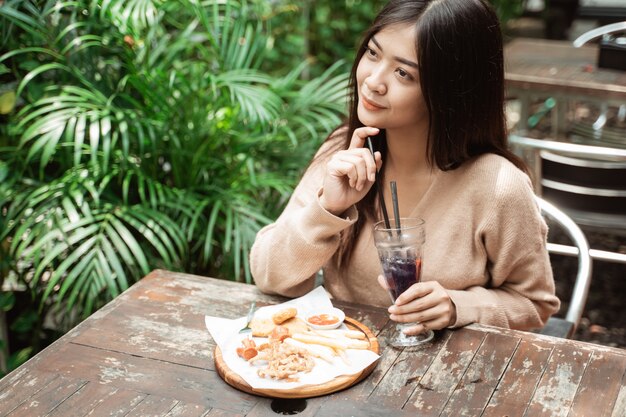 Aziatische vrouw die van lunch alleen genieten