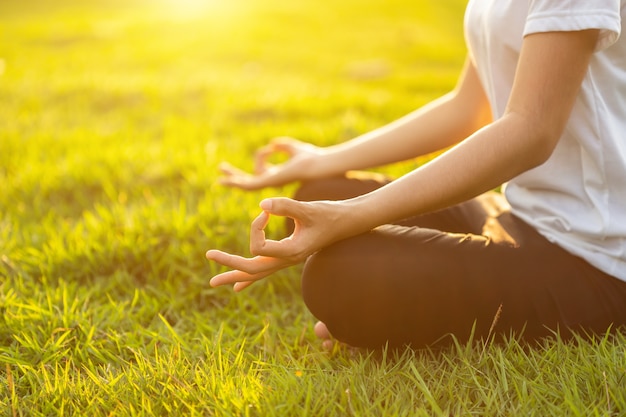 Aziatische vrouw die yogaoefeningen in het park doet