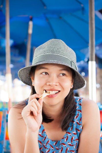 Aziatische Vrouw die zeevruchten buiten het glimlachen eten bij camera.