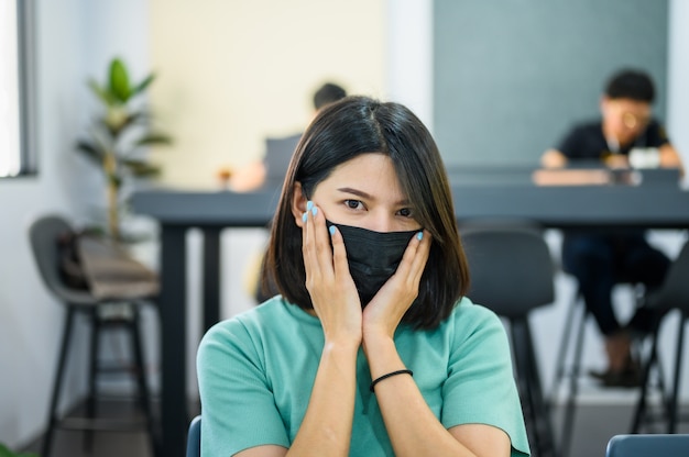 Foto aziatische vrouw die zwart medisch masker draagt