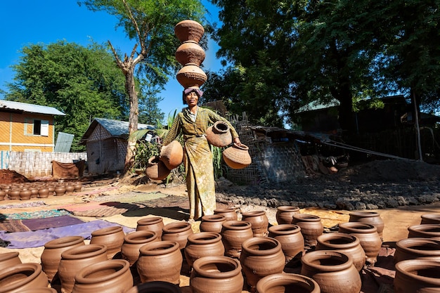 Aziatische vrouw draagt veel kruiken. myanmar