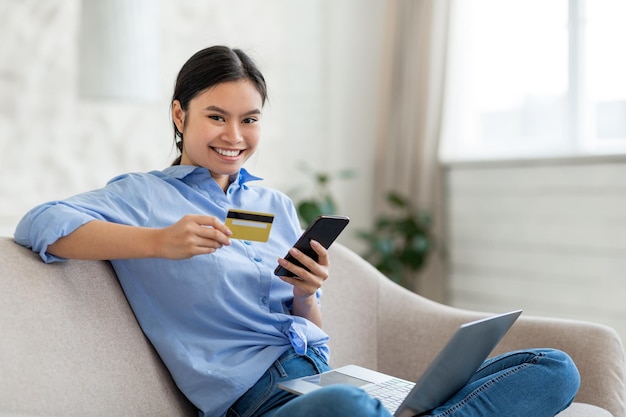 Aziatische vrouw freelancer online winkelen met smartphone en creditcard