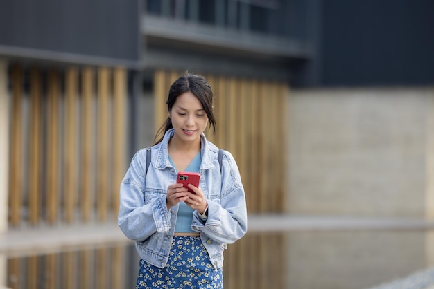 Aziatische vrouw gebruikt mobiele telefoon buiten