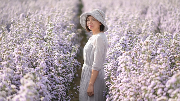 Aziatische vrouw gefotografeerd in een veld met paarse bloemen.