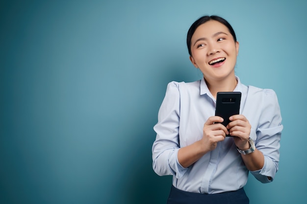 Aziatische vrouw gelukkig bericht typen met slimme telefoon geïsoleerd.