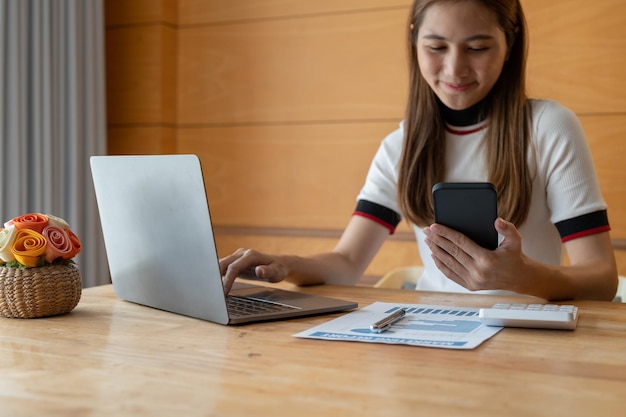 Aziatische vrouw hand met smartphone berekenen voor analyse en budget financiële boekhouding met groeistatistieken grafiek en grafiek op papierwerk boekhoudkundige financiële concept