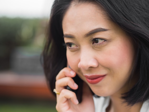 Aziatische vrouw heeft een goed blij gesprek met mobiele telefoons.