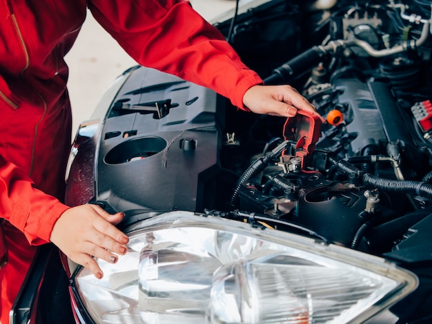 Aziatische vrouw het bevestigen van de techniek auto.