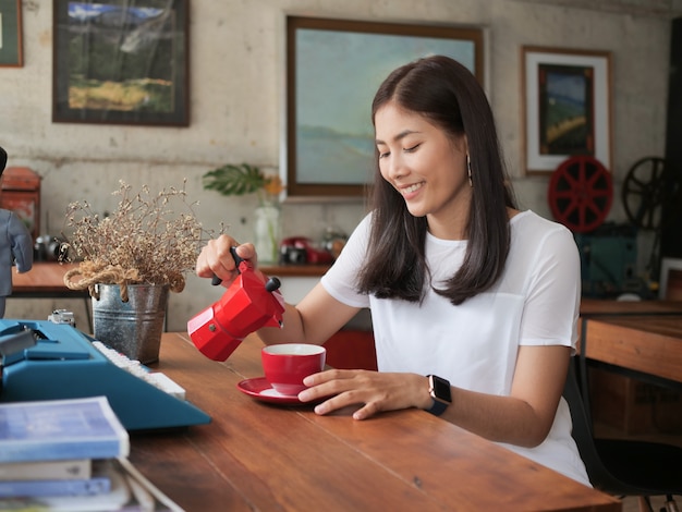 Aziatische vrouw het drinken koffie in de koffie van de koffiewinkel