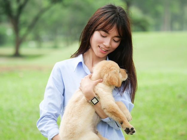 Aziatische vrouw het spelen puppyhond in park