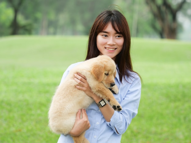 Aziatische vrouw het spelen puppyhond in park