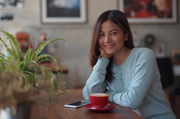 Aziatische vrouw in de koffie van de koffiewinkel