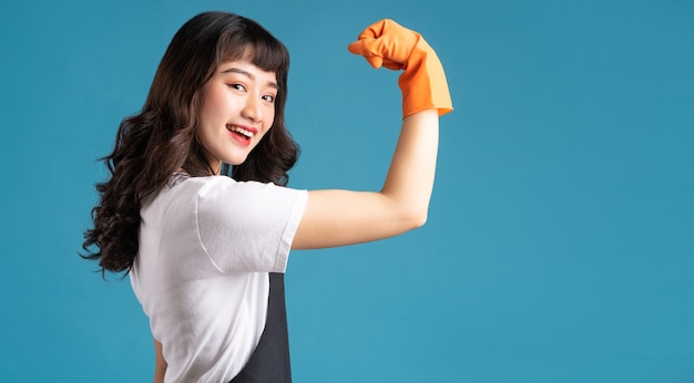 Aziatische vrouw in een schort en handschoenen die op de schoonmakende baan voorbereidingen treffen