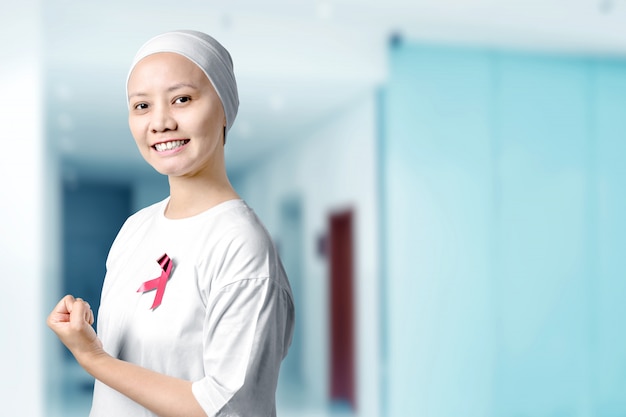 Aziatische vrouw in een wit shirt met een roze lint in het ziekenhuis
