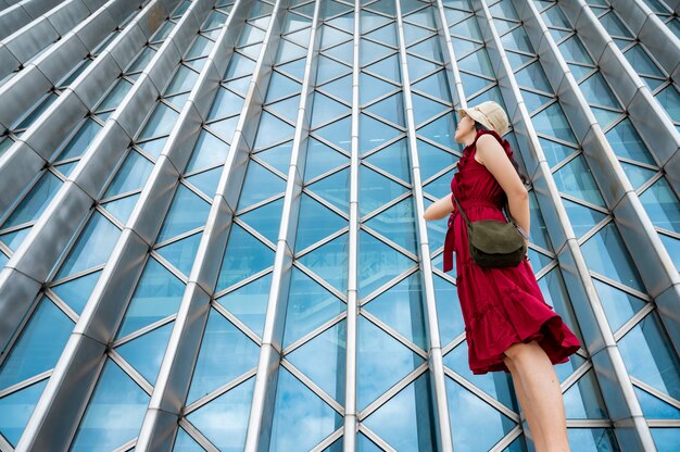 Aziatische vrouw in rode jurk in modern gebouw, vrouwelijk meisje met stedelijke stadslevensstijl