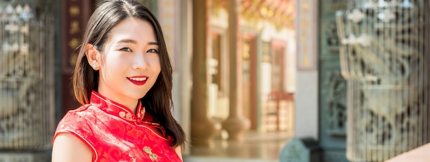 Aziatische vrouw in traditionele rode cheangsam qipao-kleding