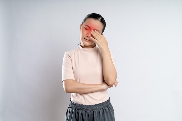 Aziatische vrouw irriteerde jeuk en raakte haar ogen aan met een rode vlek die op een witte achtergrond stond