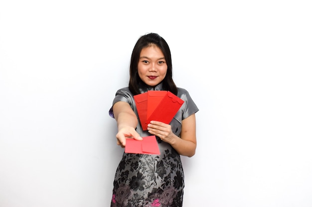 Aziatische vrouw jurk traditionele cheongsam doen wat pose en houden rode envelop angpau