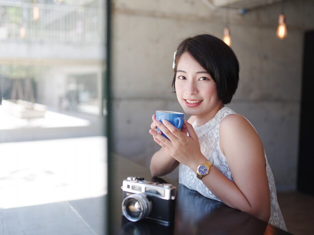 Aziatische vrouw koffie drinken in het café