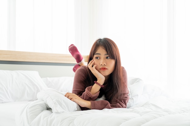 Aziatische vrouw liggend op bed in de ochtend