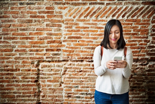 Aziatische vrouw met behulp van de mobiele telefoon