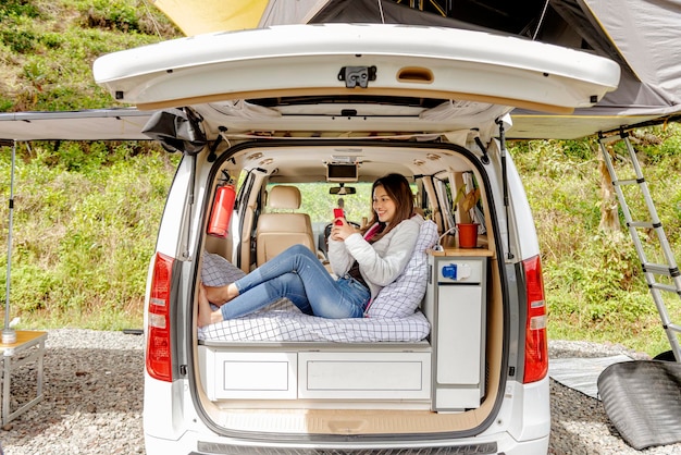 Aziatische vrouw met behulp van mobiele telefoon in de camper