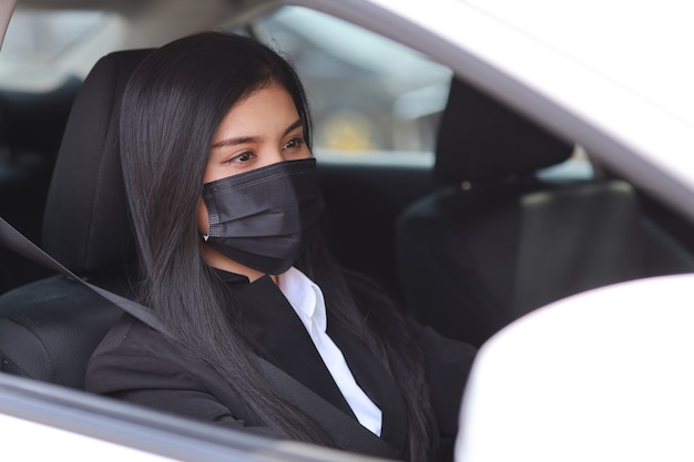 aziatische vrouw met beschermend masker in auto en auto rijden.