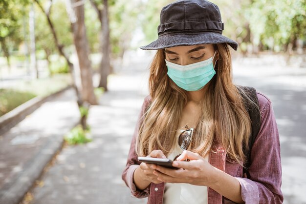 Aziatische vrouw met coronavirus die een medisch wegwerpmasker opzet om virussen te voorkomen