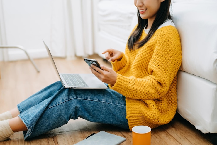 Foto aziatische vrouw met de smartphone, laptop en tablet op de bank thuis