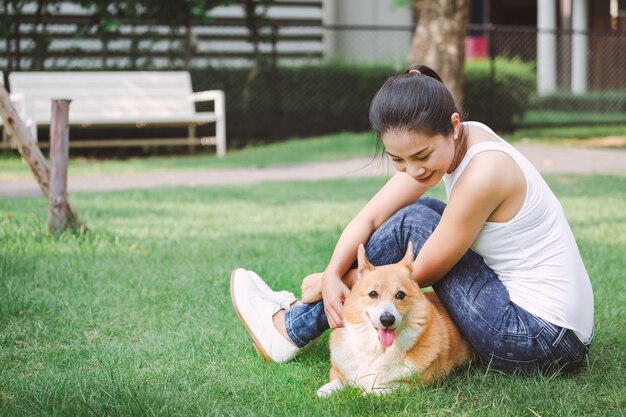 Aziatische vrouw met de Welse hond van Corgi Pembroke