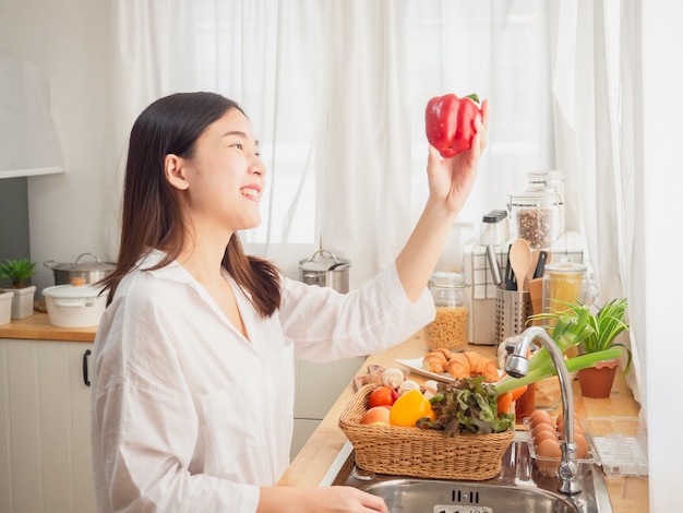 Aziatische vrouw met fruit in de keuken