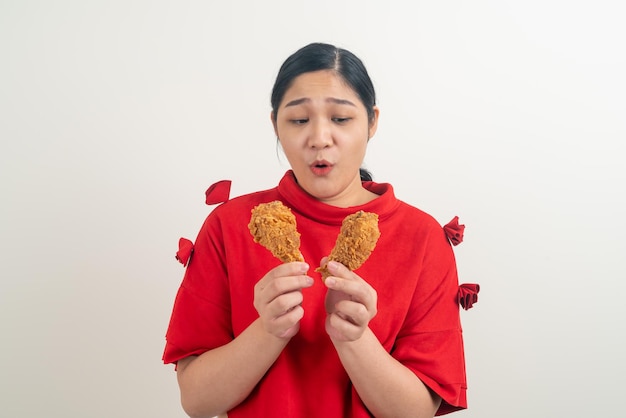 Aziatische vrouw met gebakken kip bij de hand