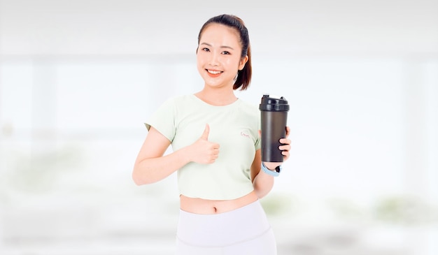 Aziatische vrouw met gezonde voeding eiwitshake drinken voor sport en fitness