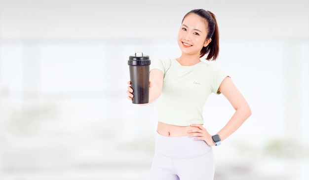 Aziatische vrouw met gezonde voeding eiwitshake drinken voor sport en fitness