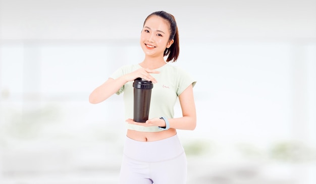 Aziatische vrouw met gezonde voeding eiwitshake drinken voor sport en fitness