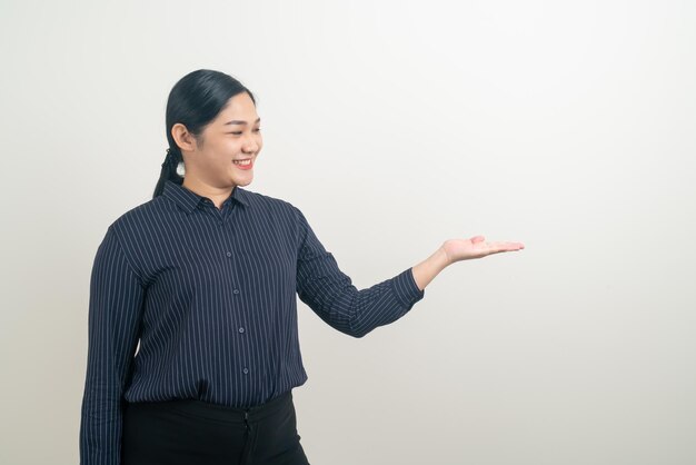 Aziatische vrouw met hand die op muur voorstelt