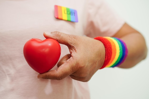 Aziatische vrouw met rood hart met regenboogvlag LGBT-symboolrechten en gendergelijkheid LGBT Pride Month in juni