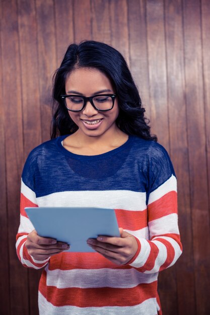 Aziatische vrouw met tablet tegen houten muur