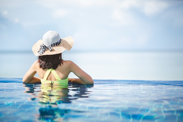 Aziatische vrouw ontspannen in het zwembad op het strand