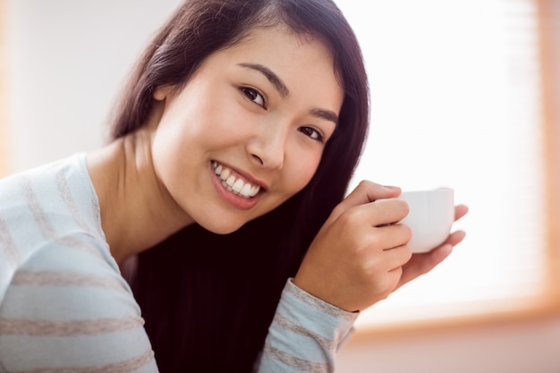 Aziatische vrouw ontspannen op de bank met koffie