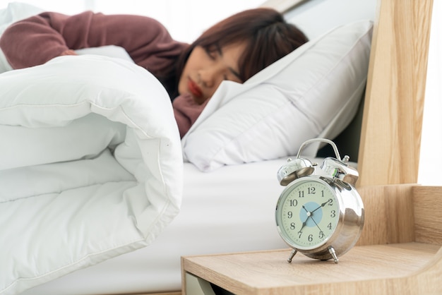 Aziatische vrouw op bed en wakker in de ochtend