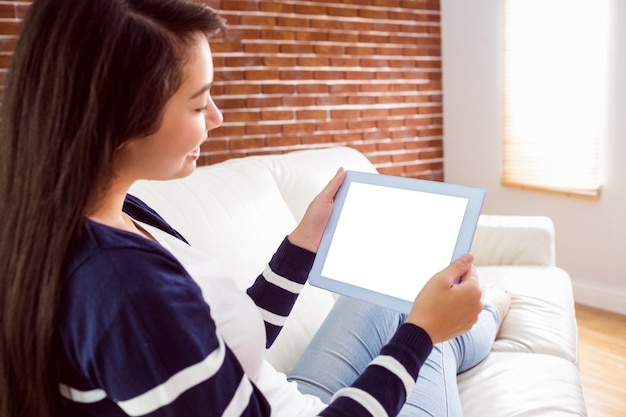 Aziatische vrouw op de laag die tablet gebruikt