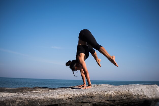 Aziatische vrouw praktijk yoga op het strand