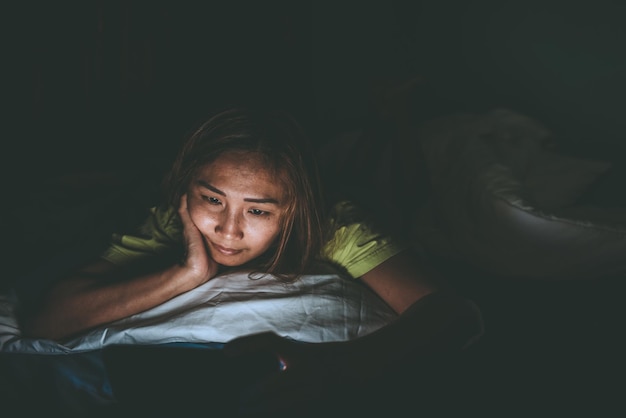 Aziatische vrouw speelt 's nachts smartphone in bed Thailand mensen Verslaafde sociale media Speel de hele nacht internet