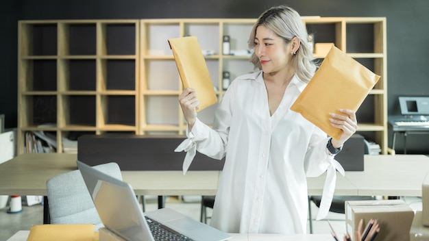 Aziatische vrouw startend klein bedrijf ondernemer freelance Jong succesbedrijf Aziatische vrouw online marketing verpakkingsdoos en leveringscontrole online bestellingen om de doos voor te bereiden die product verkoopt